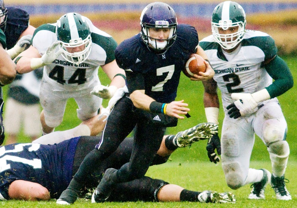 Northwestern quarterback Dan Persa breaks out from the Spartan defense as defensive ends redshirt freshman Marcus Rush, left, and sophomore William Gholston approach from the back. The Spartans defeated the Wildcats, 31-17, Saturday afternoon at Ryan Field, in Evanston, Ill. Justin Wan/The State News