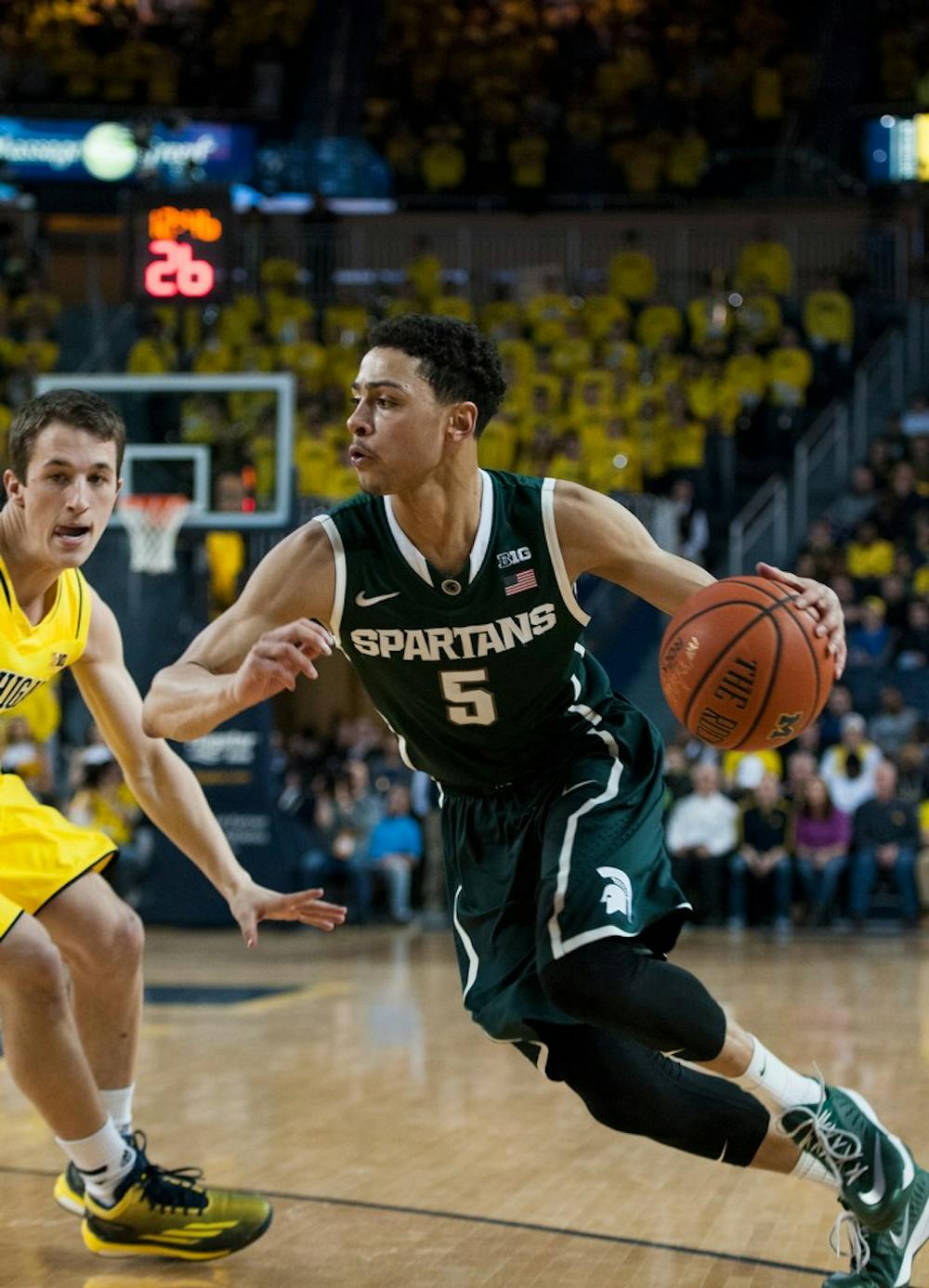 <p>Junior guard Bryn Forbes gets around Michigan guard Andrew Dakich Feb. 17, 2015, during the game against Michigan at Crisler Center in Ann Arbor. The Spartans are leading against the Wolverines at halftime, 38-23. Hannah Levy/The State News</p>
