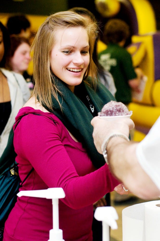 Medical technician junior Amber Suttorp gets a snow cone Saturday at Sparty's Spring Party held at the International Center, 427 North Shaw Lane. Activities of the spring party included a three-on-three basketball tournament, giveaways and inflatable games. Jaclyn McNeal/The State News