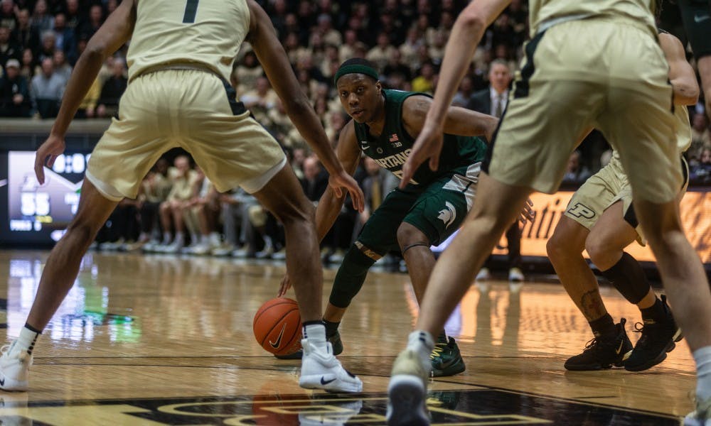 <p>Then-guard Cassius Winston (5) peers through Purdue's defense on Jan. 27, 2019 at Mackey Arena. The Spartans fell to the Boilermakers, 73-63.</p>