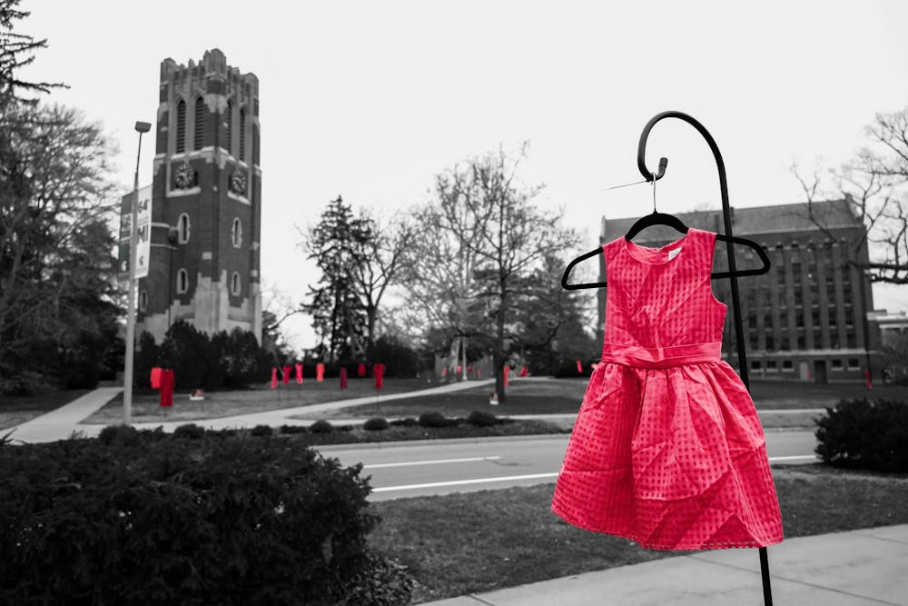 <p>A little girls red dress in front of Beaumont Tower at Michigan State University on Mar. 6, 2024. In honor of Women’s History Month, the MSU Museum, alongside the Native American Institute and various campus collaborators, introduces The REDress Project. Crafted by Métis artist Jaime Black-Morsette, this outdoor art installation aims to raise awareness about the plight of missing and murdered Indigenous women and girls. The thought-provoking exhibit will grace West Circle Drive on the Michigan State University campus from March 1 to 17, 2024. Photo Illustration by Maya Kolton.</p>