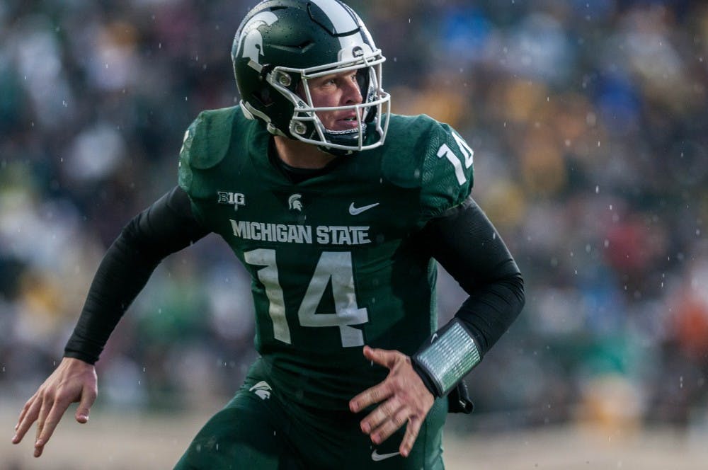 Junior quarterback Brian Lewerke (14) prepares to catch a touchdown pass during the game against Michigan at Spartan Stadium on Oct. 20, 2018. The Spartans fell to the Wolverines 7-21.
