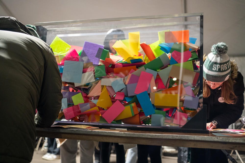 <p>MSU students and community members write messages on paper at the remembrance ceremony on Feb. 13, 2024. Their contributions will be a part of a community creation that will be displayed in the buildings affected by the shooting.</p>