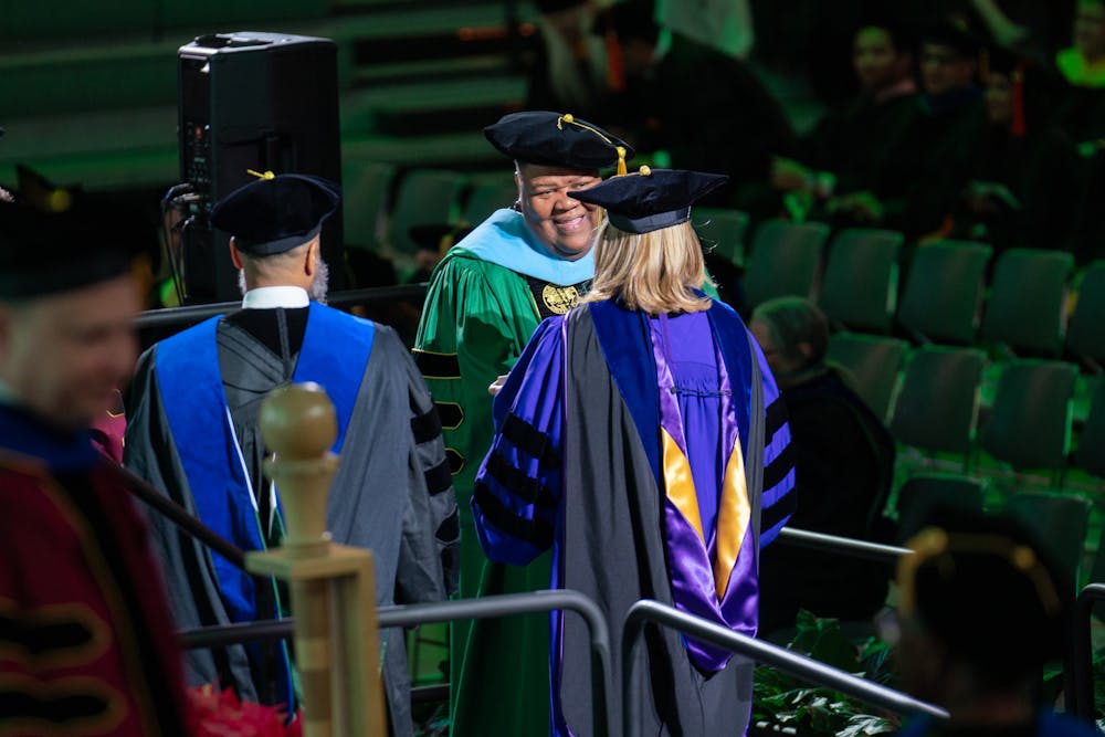 Doctoral degree recipients participating in the hooding ceremony during the advanced degree Commencement Ceremony at the Breslin Center on Dec. 12, 2023. A long-running tradition, doctoral students are hooded by their departmental mentor before receiving their degree.