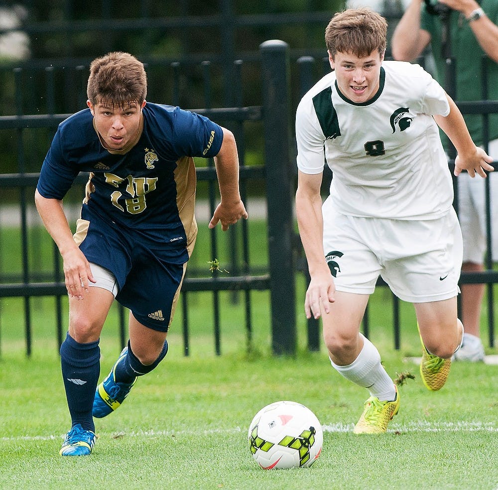 <p>Freshman midfielder Michael Marcantognini charges toward the ball alongside Florida International defender Juan Benedetty on Aug. 31, 2014, at DeMartin Soccer Stadium at Old College Field. The Spartans defeated the Panthers, 3-0. Raymond Williams/The State News</p>