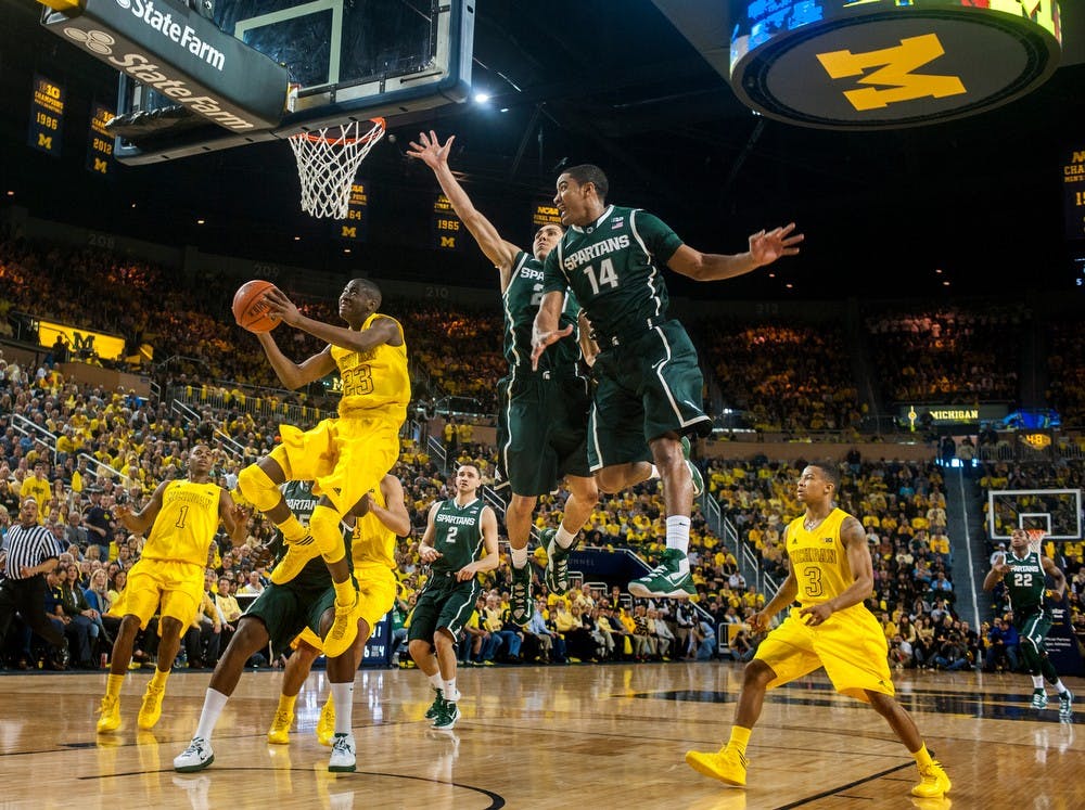 U-M guard Caris LeVert, left, attempts a field goal in the first half of the game with sophomore guard Travis Trice, center, and freshman guard Gary Harris in defense, Sunday, March 3, 2013, at Crisler Center in Ann Arbor, Mich. Justin Wan/The State News