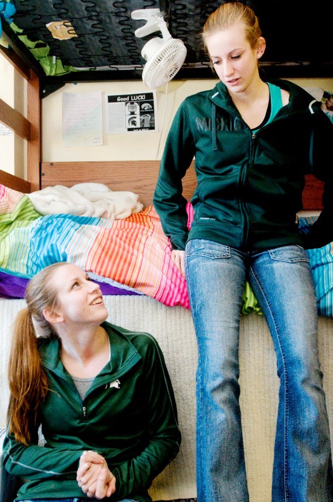 Sophomore dietetics student Erica Cultler, left, and her twin sister sophomore elementary education student Jessica Cutler, right, talk in their dorm room Thursday in Wonders Hall. The twins are on the swimming and diving team at MSU. Jaclyn McNeal/The State News