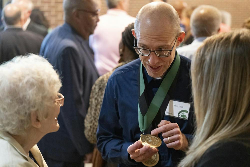 MSU Red Cedar Distinguished Professor Kevin Elliott shows off a medal to guests at a reception following the 2026 State of the University Address at the Wharton Center for Performing Arts at MSU on Tuesday, Sep 29, 2026.