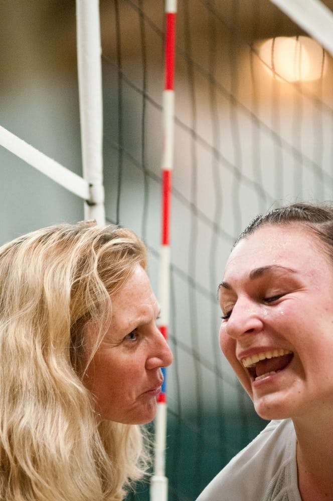 	<p>Eastern Michigan head coach Kim Berrington congratulates senior outside hitter Lauren Wicinski on her career milestone Sept. 20, 2013 at Jenison Field House. Wicinski ended the night having gone more than two thousand kills in her career. Khoa Nguyen/ The State News</p>