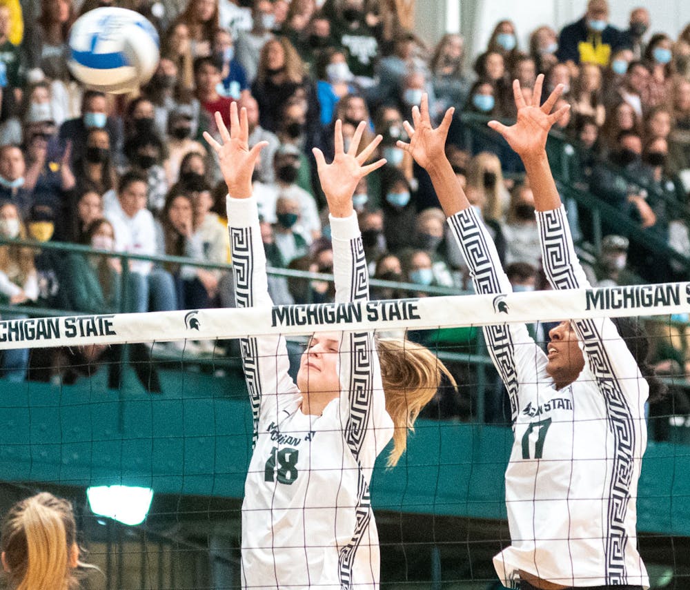 <p>Senior outside hitter Molly Johnson (18) and senior middle blocker Naya Gros (17) jump up to block an attack during the first set. The Spartans fell to the Wolverines, 3-0, during the Jam the Jension game on Nov. 21, 2021. </p>