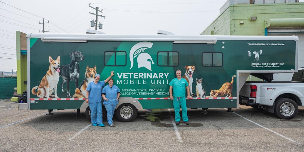 <p>MSU Assistant Professor, Dr. David Emery, and Licensed Veterinary Technicians, Katlyn Cunningham and Rebecca Wood stand in front of the MSU Veterinary Mobile Unit after completing many operations on dogs at I Heart Dogs in Warren, Mich., on July 16, 2026.</p>