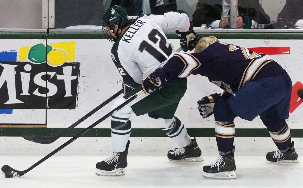 	<p>Freshman forward Ryan Keller tries to steal the puck Saturday Jan. 12, 2013, at Munn Ice Arena. The Spartans defeated Notre Dame 4-1 in the second game of the home series. Katie Stiefel/ The State News</p>