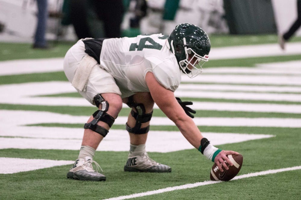 <p>Sophomore offensive lineman Matt Allen (64) prepares to snap a football during practice on April 3, 2018, inside Duffy Daugherty Football Building.</p>