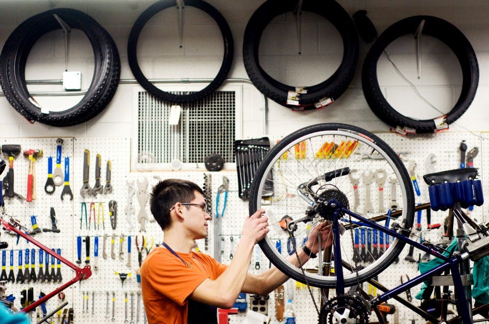 Student mechanic and mechanical engineering sophomore Daniel Dokter checks the tire on a bike he had finished repairing Tuesday morning at the Bike Store. The store is offering weekly Saturday classes on different bike topics, including how to repair a bike. Lauren Wood/The State News