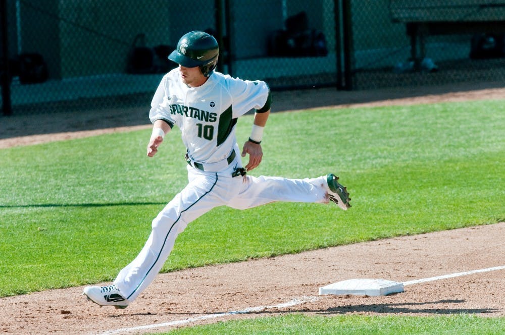 Junior infielder Ryan Jones leaps past the third base to rush for the home plate. Jones went at bat for five times and scored a run during the game. The Spartans defeated the Broncos, 13-3, Tuesday afternoon at McLane Baseball Stadium at Old College Field. Justin Wan/The State News