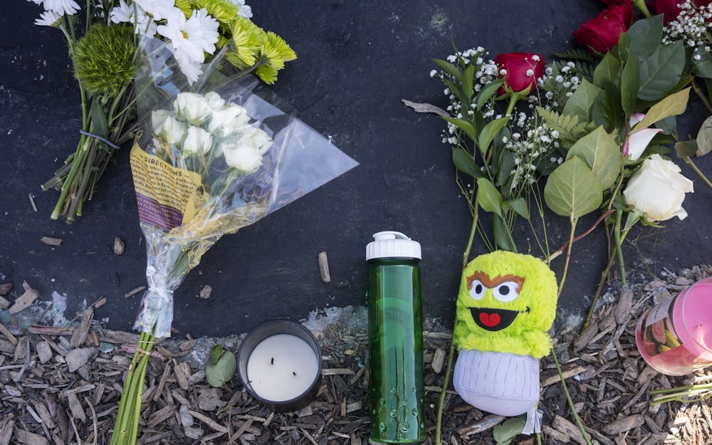 Flowers, candles and other memorabilia sit at the foot of the Rock on Farm Lane in remembrance of the victims of the mass shooting on Monday, Feb. 13, 2023 in Michigan State University’s North Neighborhood.