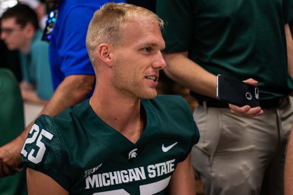 Redshirt senior punter Jake Hartbarger (25) answers questions from the media on Aug. 6 at Spartan Stadium.