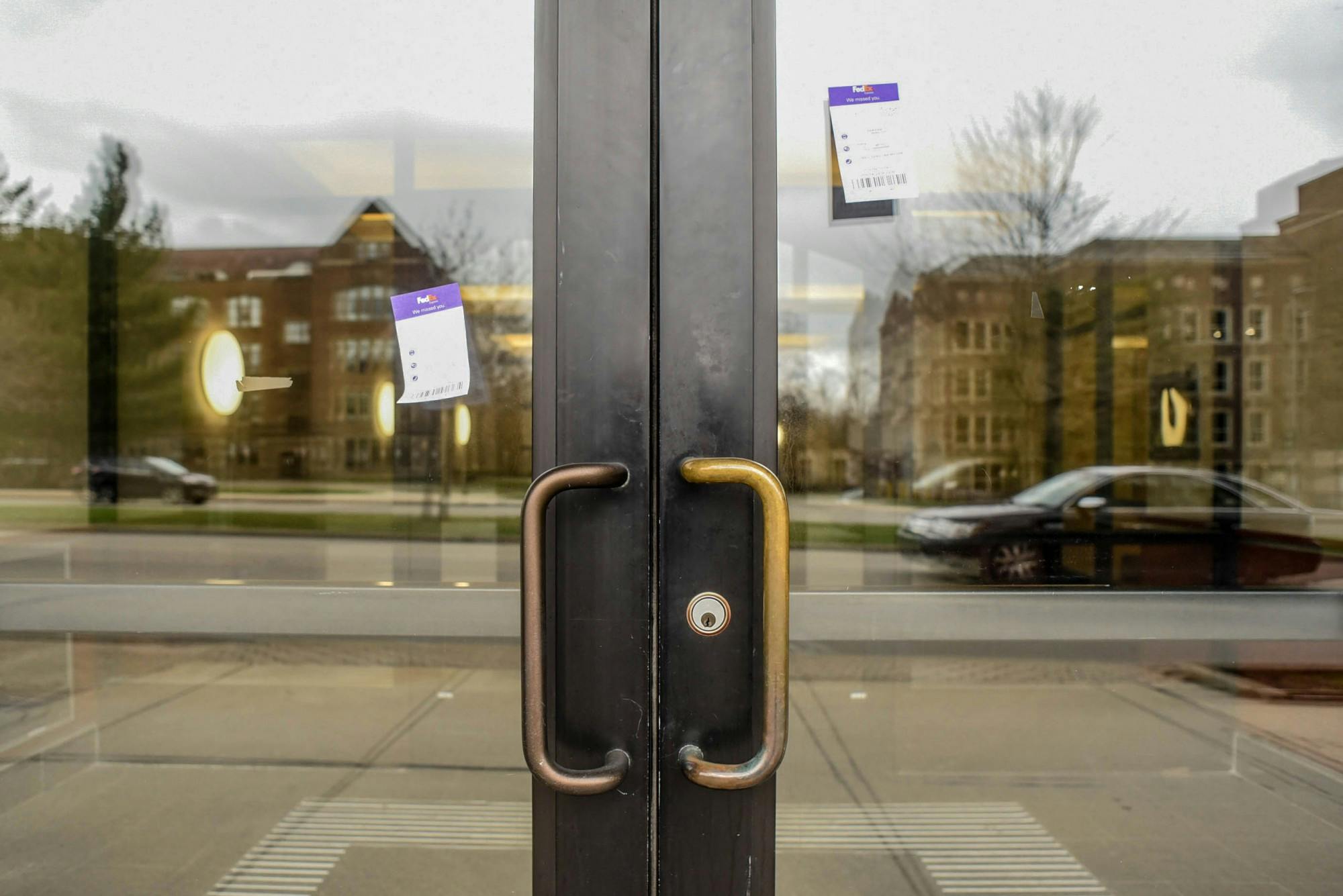 Fed Ex missed packages notices on a door in downtown East Lansing on April 1, 2020.