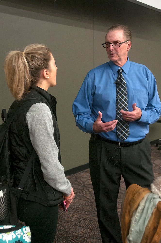 <p>Eli Broad College of Business professor Charlie Bokemeier talks with one of his assistants Samantha Sokan before beginning class April 6, 2015, in the Business College Complex. Kelsey Feldpausch/The State News</p>