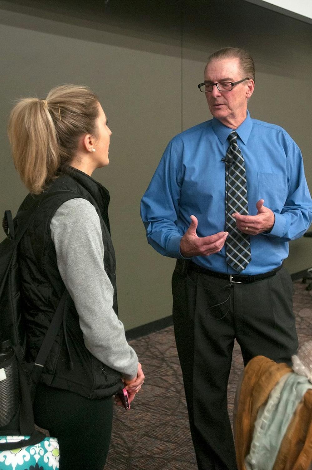 <p>Eli Broad College of Business professor Charlie Bokemeier talks with one of his assistants Samantha Sokan before beginning class April 6, 2015, in the Business College Complex. Kelsey Feldpausch/The State News</p>