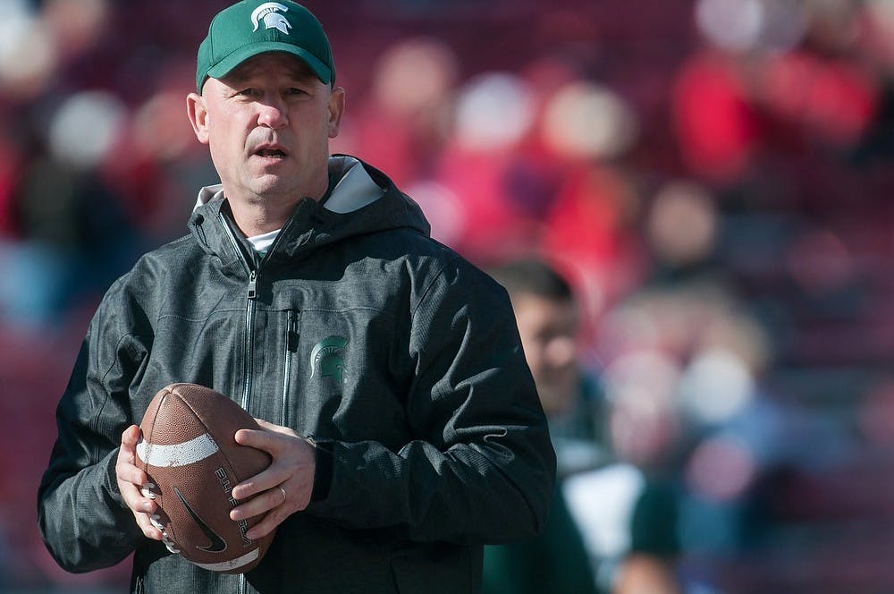 Offensive coordinator Dan Roushar warms up with the team before the game Saturday, Oct. 27, 2012, at Camp Randall Stadium in Madison, WI. The Spartans defeated the Wisconsin Badgers 16-13 with an overtime touchdown for the win. Adam Toolin/The State News