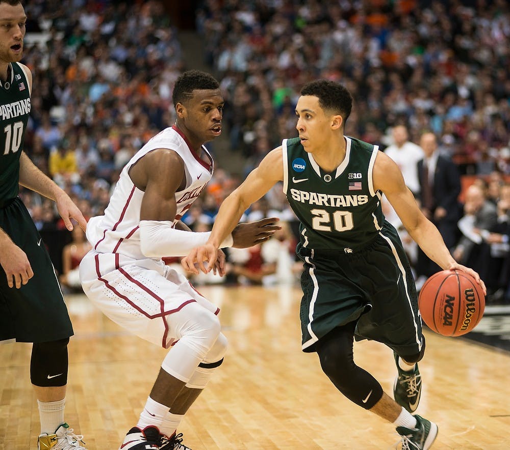 <p>Senior guard Travis Trice dribbles the ball down the court March 27, 2015, during the East Regional round of the NCAA Tournament during a game against Oklahoma at the Carrier Dome in Syracuse, New York. The Spartans defeated the Sooners, 62-58. Erin Hampton/The State News</p>
