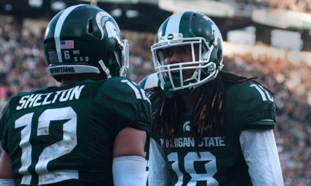 Senior wide receiver R.J Shelton (12), left, talks with sophomore wide receiver Felton Davis III (18) after scoring a touchdown in the third quarter during the game against Northwestern on Oct. 15, 2016 at Spartan Stadium. Shelton caught the 86 yard pass from senior quarter back Tyler O'Connor (7).