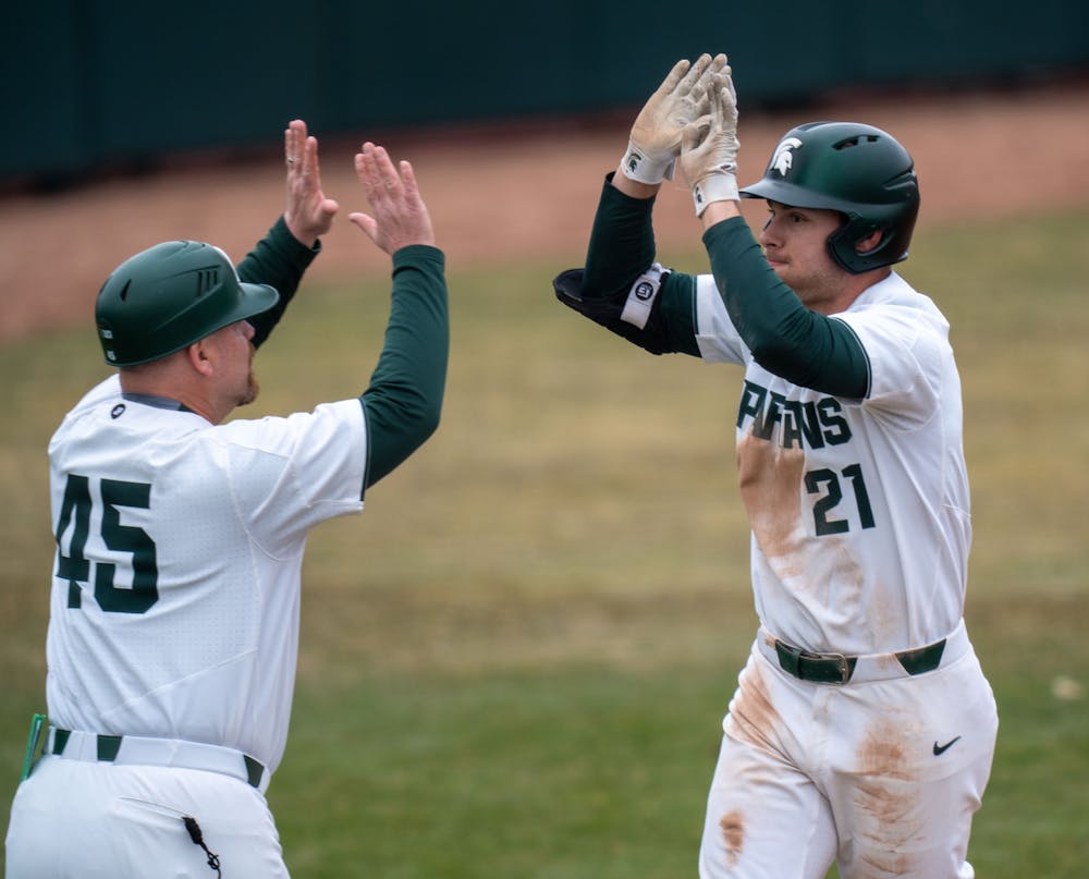 After hitting a home-run, sophmore Jack Frank runs around the bases giving a high-five to assistant coach Graham Sikes. MSU won 4-3 on March 18, 2022 against Houston Baptist