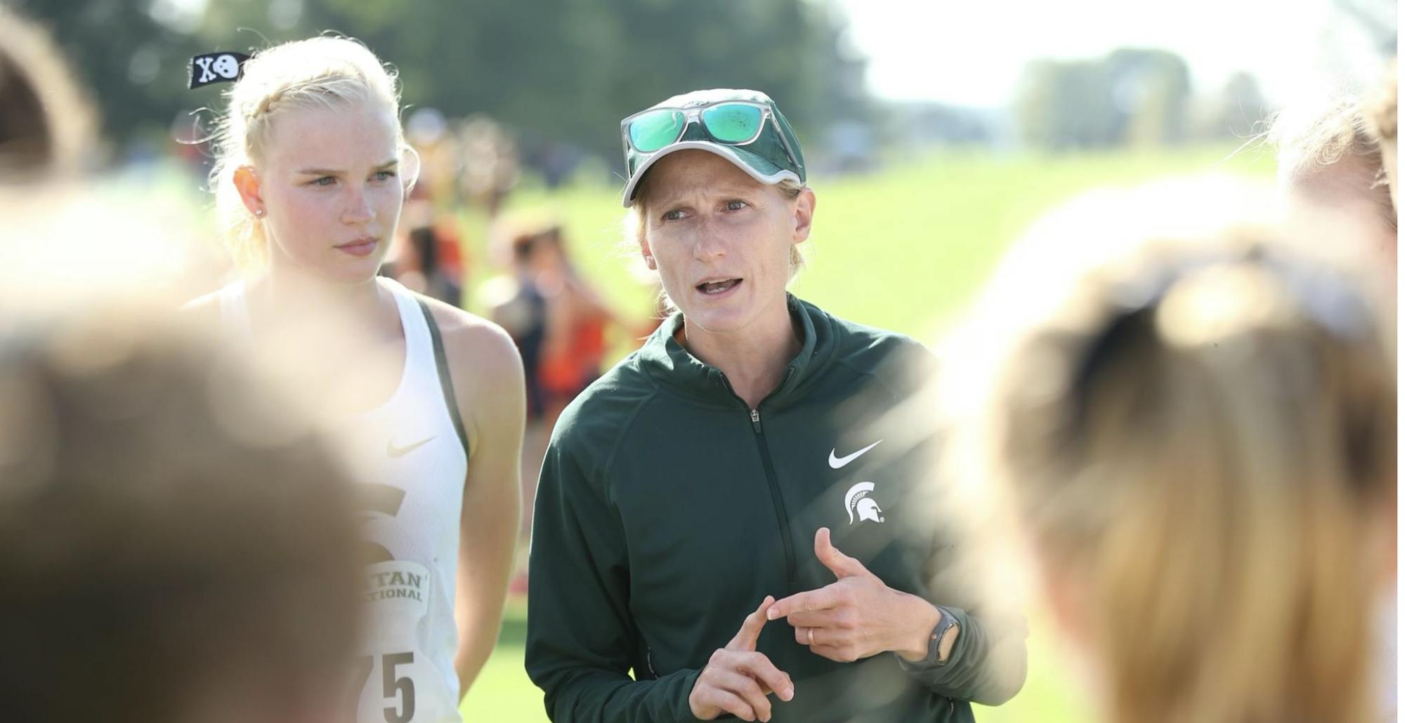 MSU Track and Field head coach Lisa Breznau speaking to her team during a huddle at an event. Photo courtesy of Michigan State Spartan Athletics.