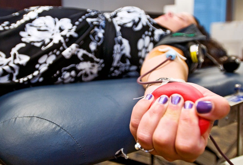 	<p>Tricia Bradford of Lansing reclines while donating blood to the American Red Cross in the Patenge Room of Fee Hall on Wednesday morning.  Bradford supports the College of Osteopathic Medicine in a blood drive challenge against the College of Veterinary Medicine.</p>