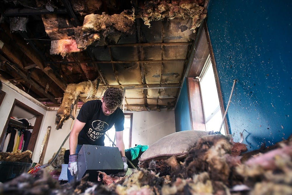 	<p><span class="caps">MSU</span> alumnus Zack Slizewski cleans a room damaged by an early morning fire at Phoenix cooperative, 239 Oakhill Ave, on Wednesday, Sept. 4. Julia Nagy/The State News</p>