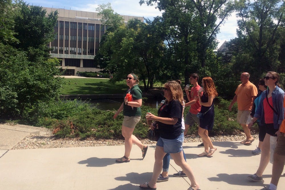 <p>Hannah Robar, MSU senior and Studio Arts and Global Studies major, leads a tour of high school students and parents July 22, 2015 along the Red Cedar River during Green and White Day. Ryan Kryska/The State News</p>
