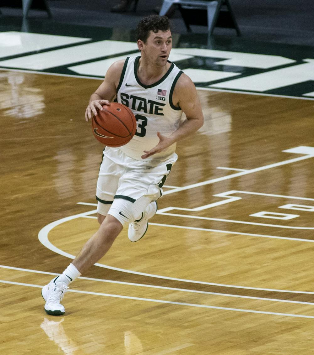 Junior guard Foster Loyer (3) dribbles the ball down the court in the second half while communicating with his teammates. Michigan State triumphed over Notre Dame, 80-70, on Nov. 28, 2020. 