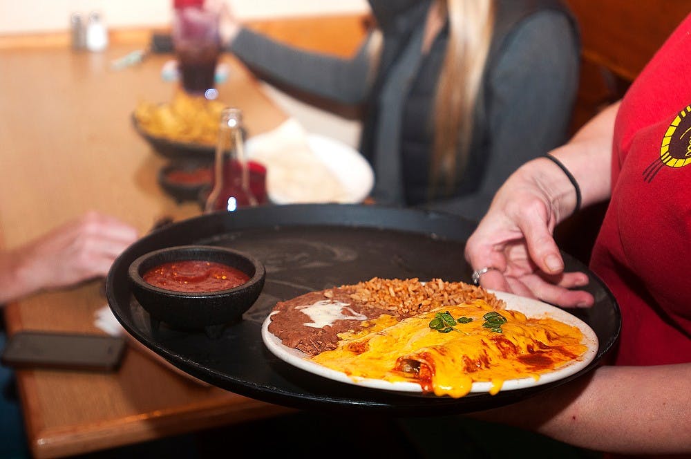 <p>Lansing resident Tammy Gubert serves food to customers Oct. 9, 2014, at El Azteco on Albert Avenue. Gubert said that she enjoys the busy atmosphere that comes with working at El Azteco. Jessalyn Tamez/The State News. </p>