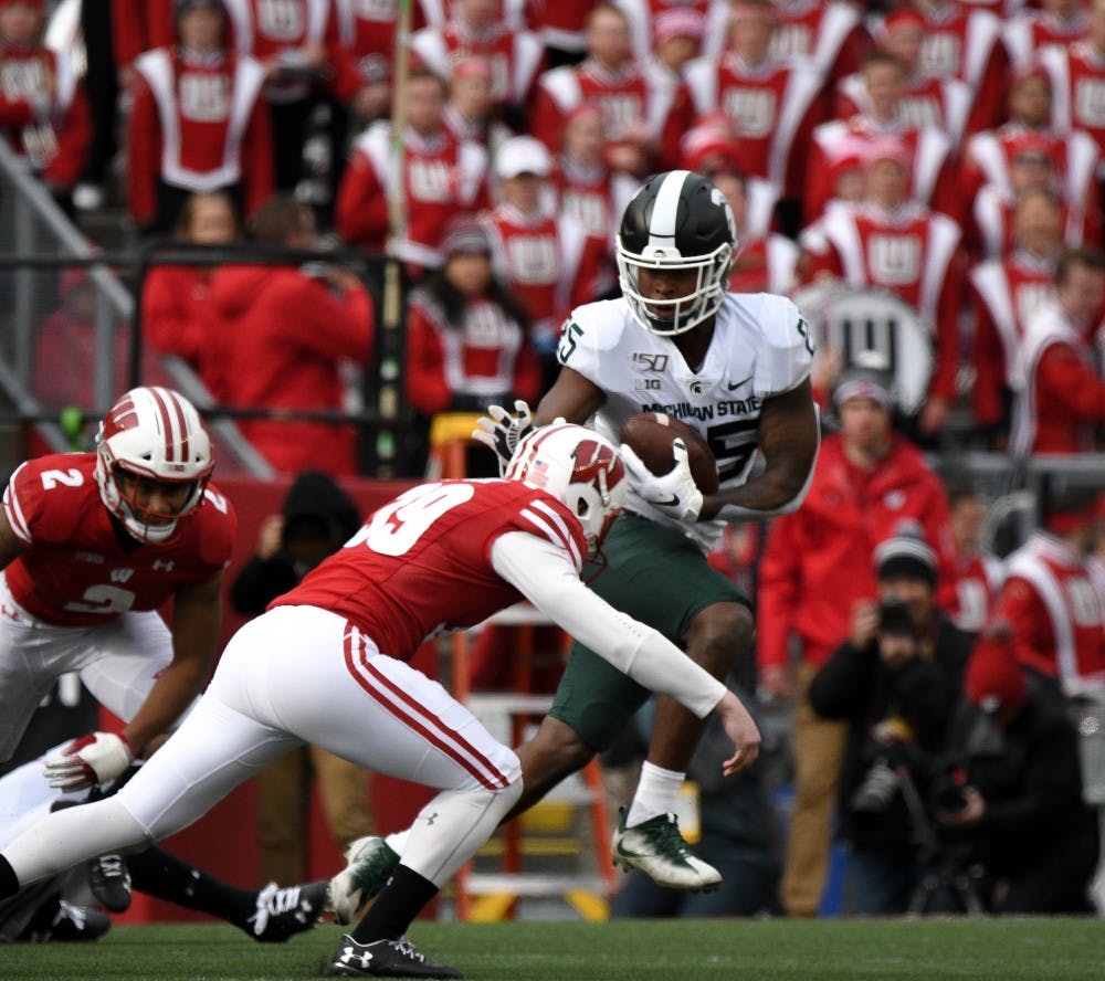 <p>Senior wide receiver Darrell Stewart Jr. (25) attempts to break a tackle during the game against Wisconsin at Camp Randall Stadium on October 12, 2019. The Spartans lost to the Badgers 38-0. </p>