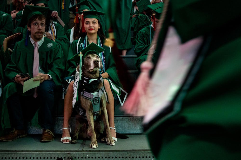 Ahleigh Clara Kumiko Weiszbrod and her dog, Mochi, watch the Michigan State University College of Communication Arts and Sciences graduation ceremony at the Breslin Student Events Center on Michigan State University’s campus in East Lansing, Mich., on Friday, May 1, 2026.