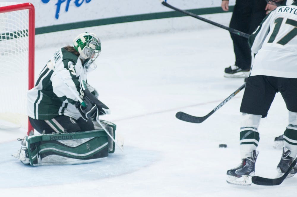 <p>Junior goaltender Jake Hildebrand stops a shot March 6, 2015, during the game against Wisconsin at Munn Ice Arena. The Spartans defeated the Badgers 3-0. Kennedy Thatch/The State News</p>