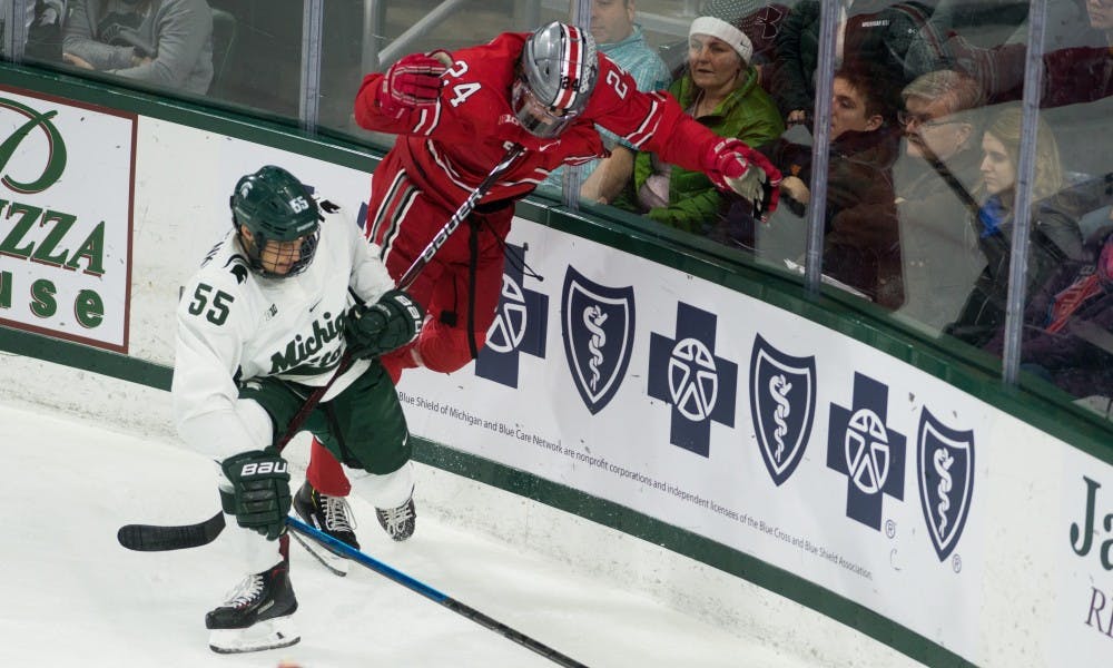 Ohio State left wing Ryan O'Connel (24) falls over junior center Patrick Khodorenko (55) during the game against Ohio State University at Munn Ice Arena on Jan. 5, 2019. The Spartans fell to the Buckeyes, 6-0.