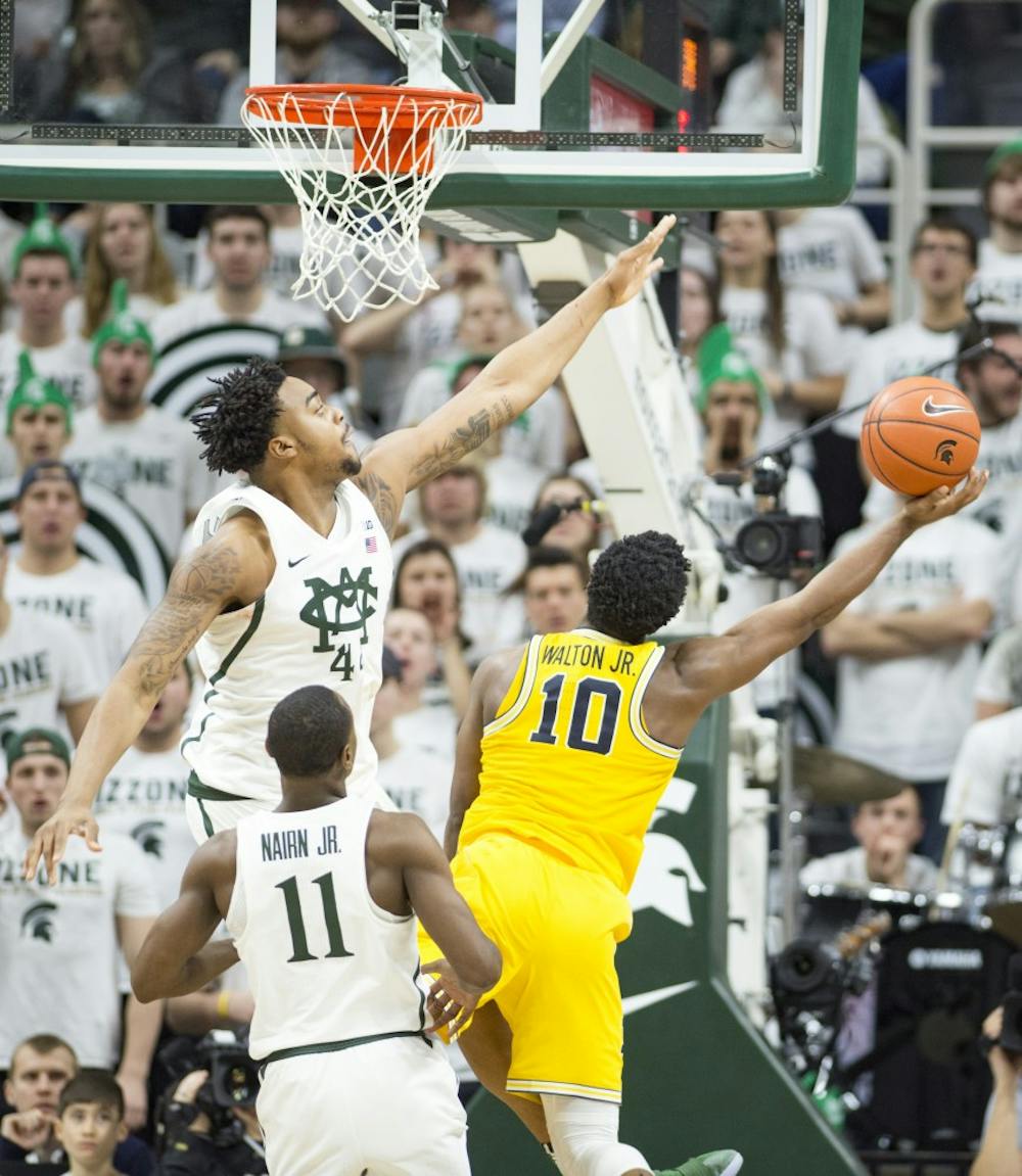 Freshman forward Nick Ward (44) attempts to block University of Michigan guard Derrick Walton Jr. (10) as he shoots the ball during the second half of the men's basketball game against the University of Michigan on Jan. 29, 2017 at Breslin Center. The Spartans defeated the Wolverines, 70-62.
