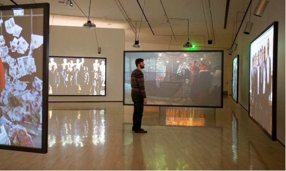 Chemistry senior Kurt Hamel looks at video that is projected on a screen on Dec. 8, 2015 at the Eli and Edythe Broad Art Museum. The exhibit "Moving Time: Video Art at 50, 1965–2015" highlights the development of video art from the past to the present.