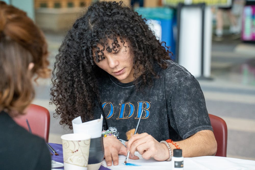 <p>Freshman Ralph Pruitt paints a bandana during, "It's On Us Week," on April 5, 2023, in Brody Square Atrium.&nbsp;</p>
