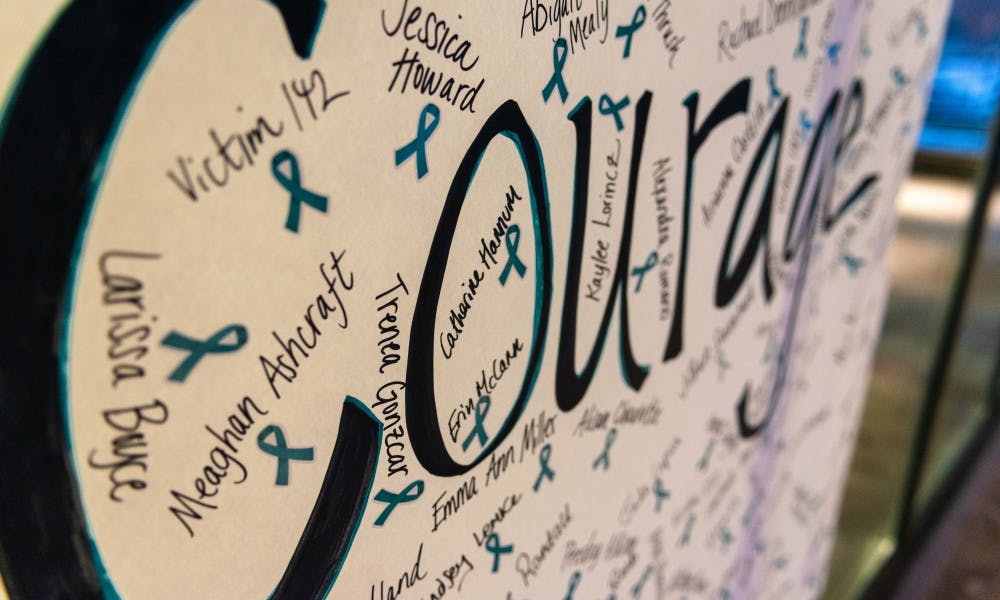 <p>Reclaim MSU hung a banner reading &quot;Courage&quot; on the front window of the Hannah Administration Building for a rally on Jan. 24, 2019. The banner was signed by many people, both survivors and supporters.</p>