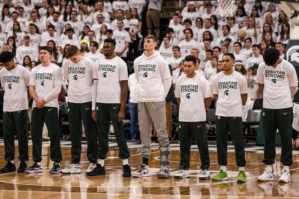 <p>The MSU Men's basketball team takes a moment of silence and stand together in their Spartan Strong shirts before facing Indiana on Feb. 21, 2023.</p>