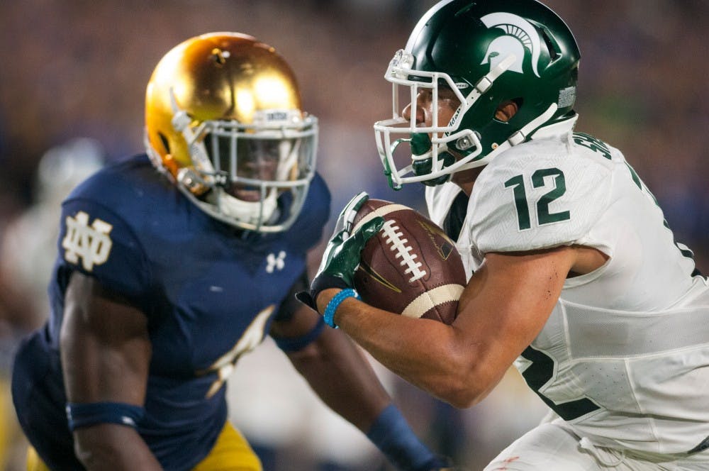 Senior wide receiver R.J. Shelton (12) carries the ball down the field while being covered by Notre Dame linebacker Te'von Coney (4) during the game against Notre Dame on Sept. 17, 2016 at Notre Dame Stadium in South Bend, Ind. The Spartans defeated the Fighting Irish, 36-28.