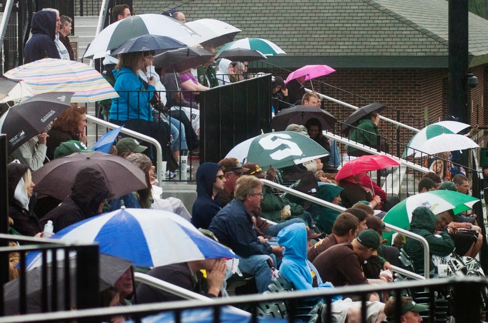 Baseball fans huddle under umbrellas as it rained when Michigan State faced Iowa Saturday afternoon at McLane Baseball Stadium at Old College Field. The Spartans lost to the Hawkeyes 2-1.Samantha Radecki/The State News