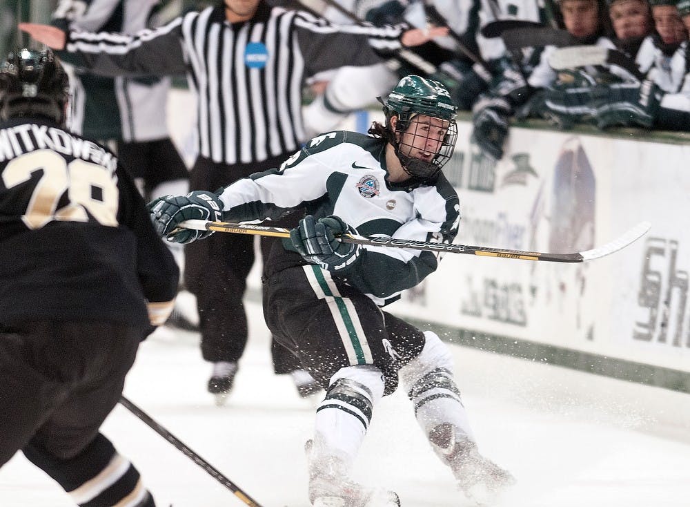 Junior center Lee Reimer dumps the puck into the offensive zone Friday, March 1, 2013, at Munn Ice Arena. Western Michigan defeated the Spartans, 5-2, during the first game of the weekend series. Adam Toolin/The State News