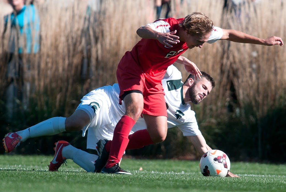 	<p>Sophomore midfielder Sean Conerty falls behind Ohio State midfielder Ryan Ivancic while fighting  for control of the ball during a game on Oct. 13, 2013, at DeMartin Stadium at Old College Field. The Spartans tied the Buckeyes, 1-1. Georgina De Moya/The State News</p>