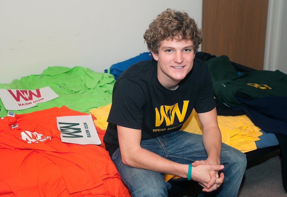 Economics sophomore Ryan Hagan poses with several of his shirts for his charity organization, World United Organization, on Oct. 31, 2012, in his apartment. Hagan has been selling shirts since his junior year in high school, and plans to make a trip to Africa in the future for the organization. Danyelle Morrow/The State News