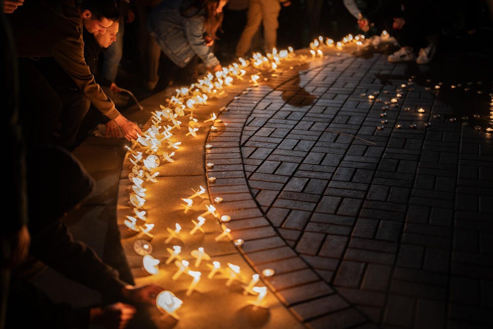<p>Candles surround the base of Spartan Statue during a vigil held for the war in Israel-Gaza on Oct. 9, 2023, in East Lansing.</p>