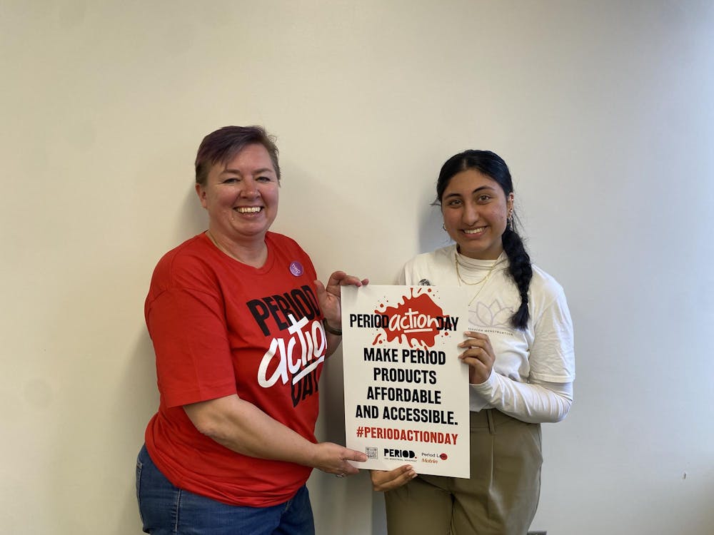Lysne Tait and Nupur Huria holding a Period Action Day sign.